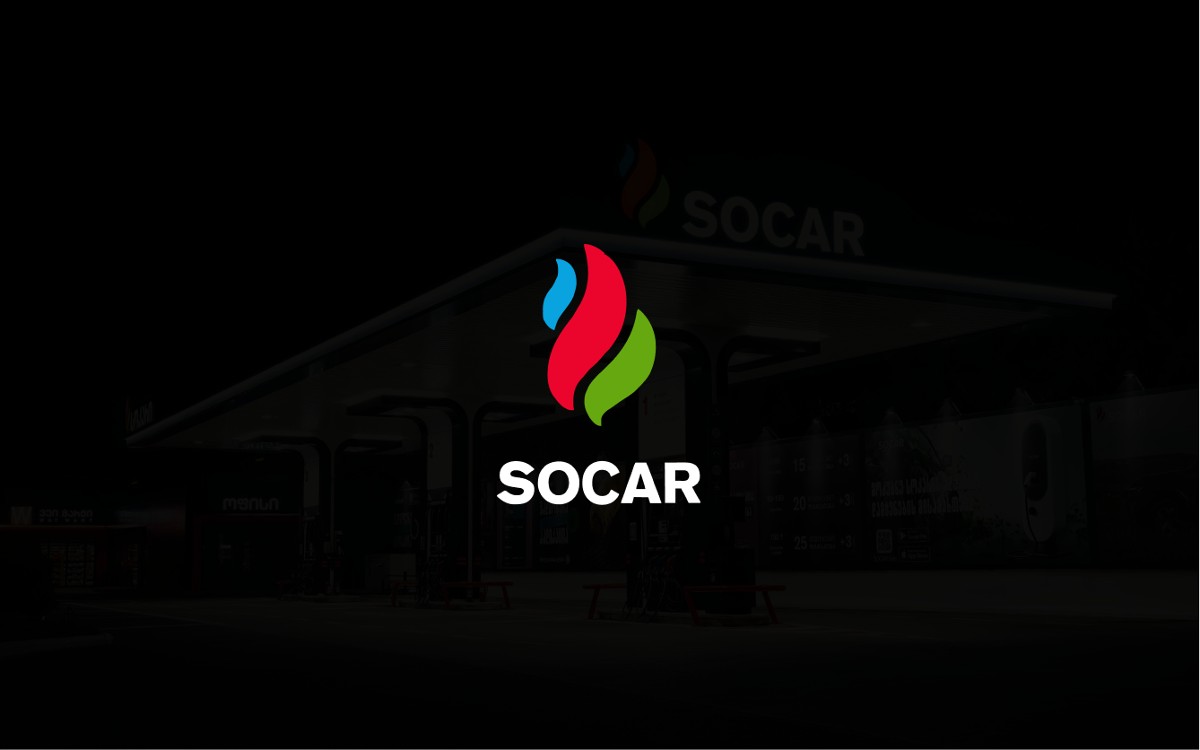 SOCAR gas station at night with the multicolor flame logo glowing on black